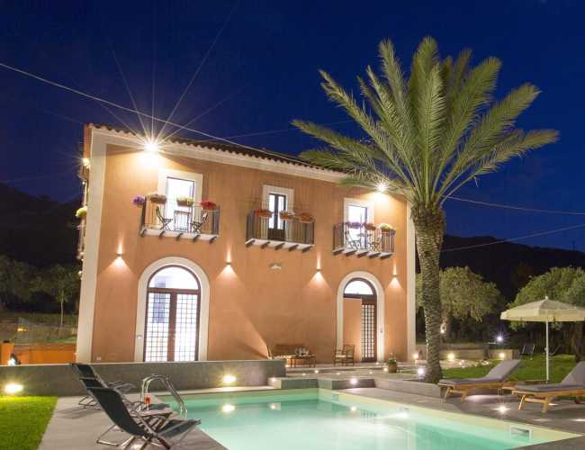 Casa con piscina di notte illuminata