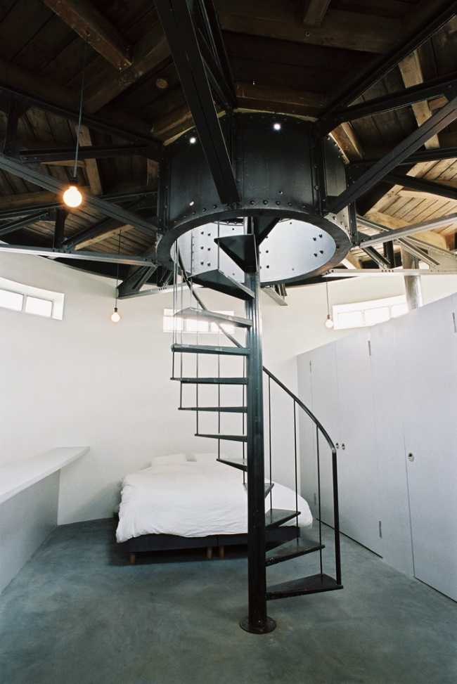 camera da letto in una torre con scala in metallo