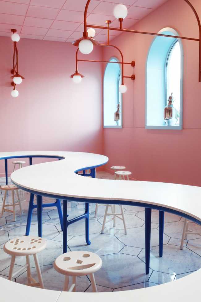 Groninger Museum tavolo continuo curvo bianco pareti rosa e luce sospesa rossa