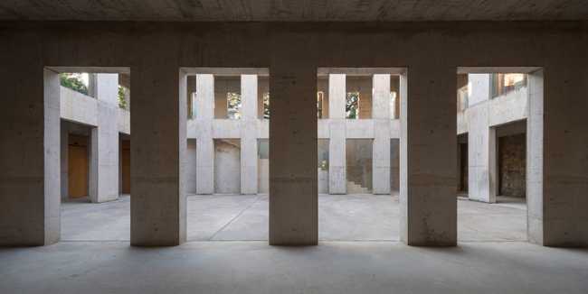 Briques, cours, arbres luxuriants. Rénovation d'un bâtiment datant des années 80