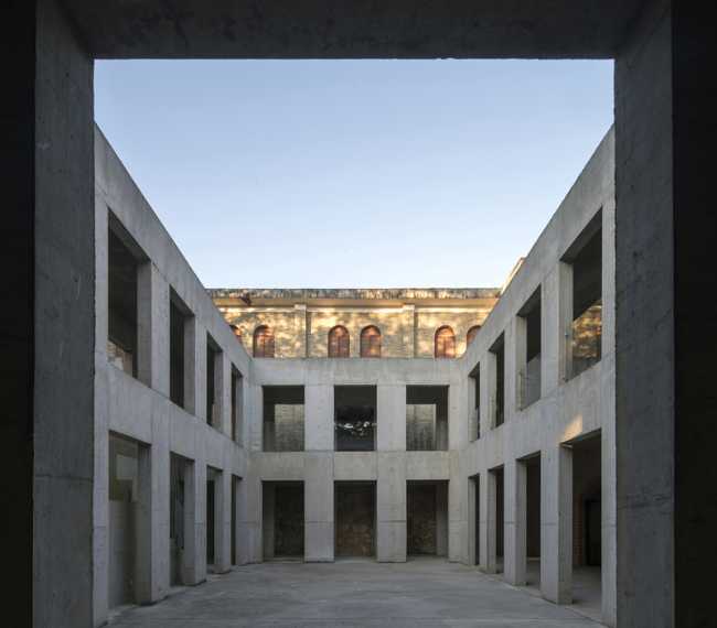 Briques, cours, arbres luxuriants. Rénovation d'un bâtiment datant des années 80