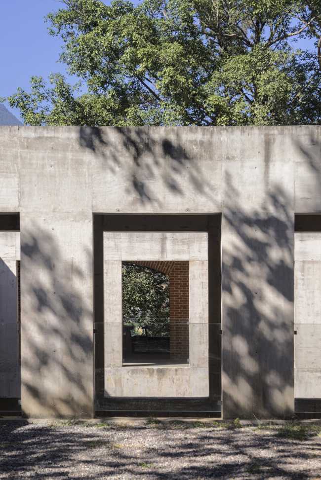 Briques, cours, arbres luxuriants. Rénovation d'un bâtiment datant des années 80