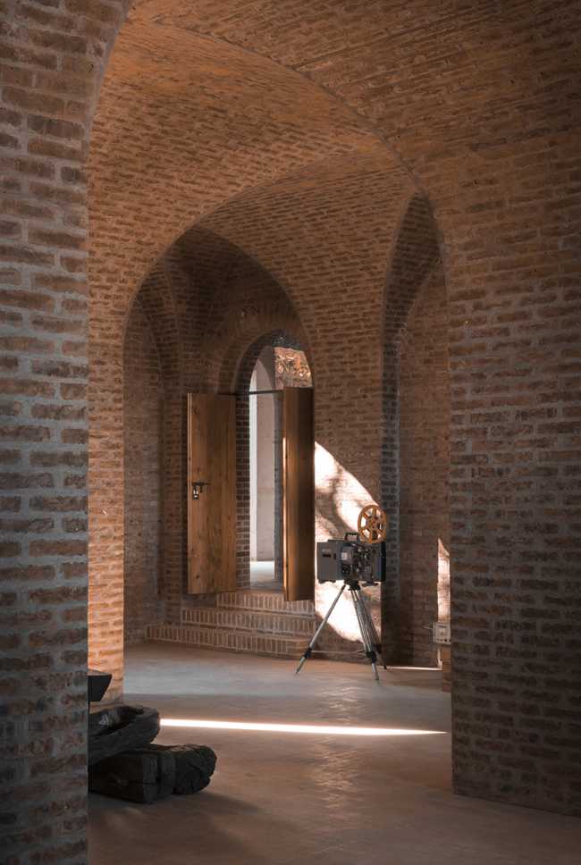 Briques, cours, arbres luxuriants. Rénovation d'un bâtiment datant des années 80