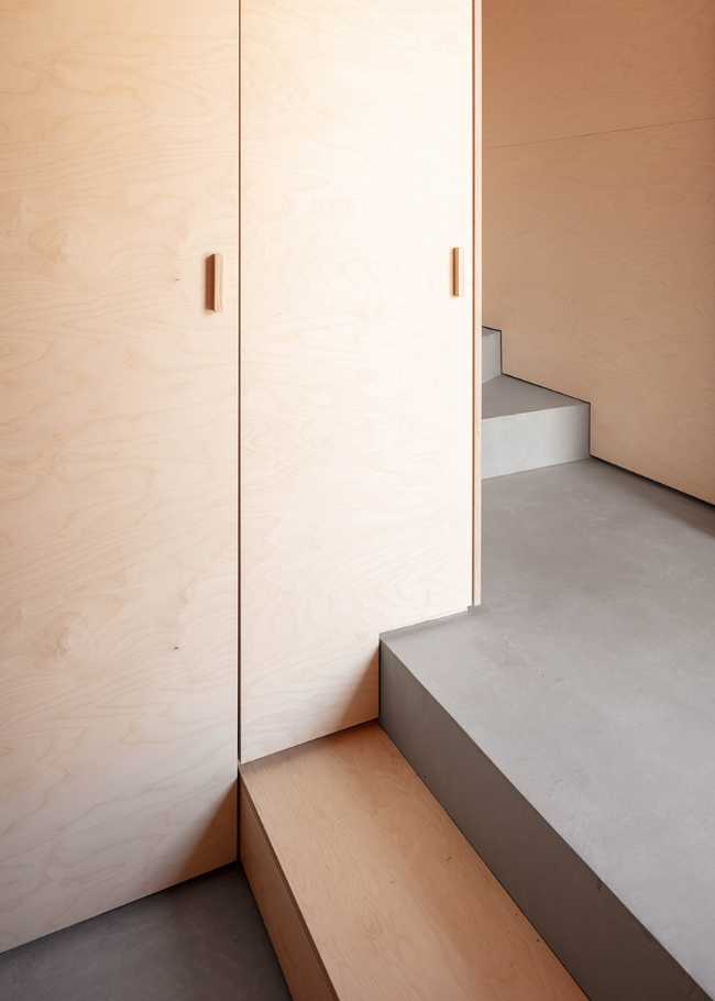 Wooden spaces and gray internal staircase