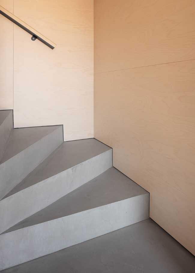 Wooden spaces and gray internal staircase