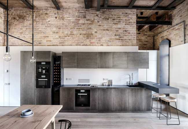 Steel kitchen in contrast with masonry walls