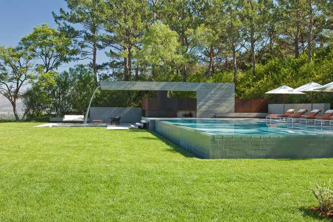 Piscina monumental de hormigón y prado verde