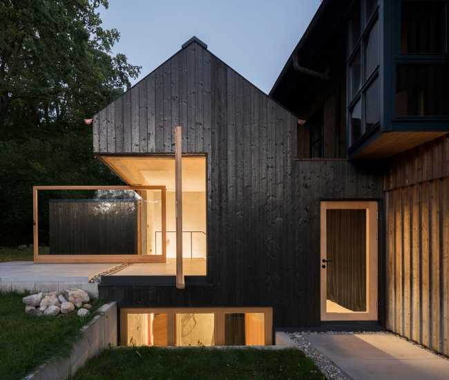 Maison avec une façade en bois brûlé.