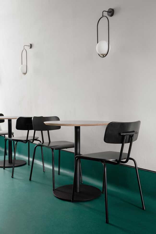 Mesa de centro negro suelo verde pared blanca