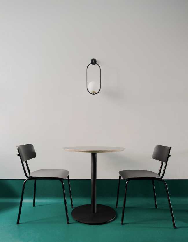 Mesa de centro negro suelo verde pared blanca