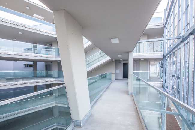 Residential complex facade perforated sheet metal corridor connections