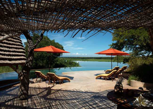 Lodge in legno sul fiume con ombrelloni