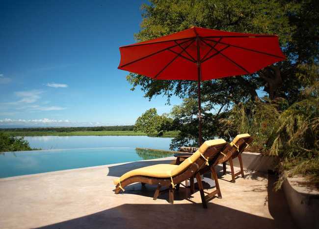 Lodge in legno sul fiume con ombrelloni