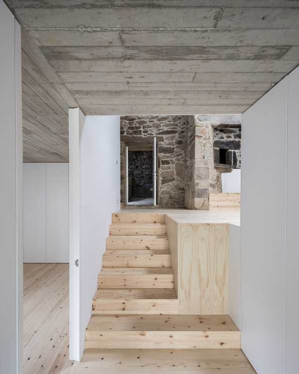 Interior de piedra de hormigón y madera con particiones blancas