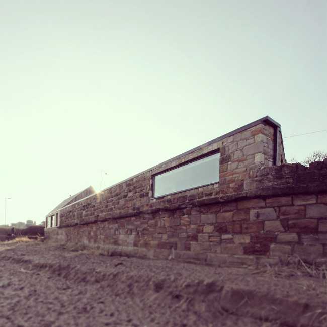 Abitazione in legno sulla spiaggia con vetrata vista mare