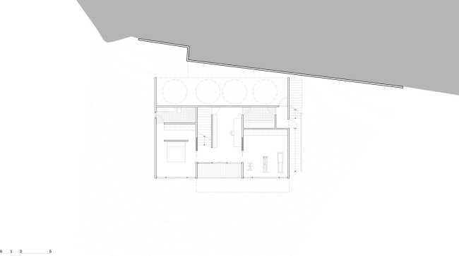 Maison perchée sur une colline. Extérieur sombre et intérieur avec vue sur l'océan