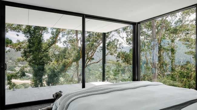 Maison perchée sur une colline. Extérieur sombre et intérieur avec vue sur l'océan