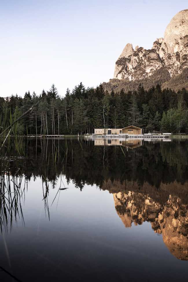 Baita che si specchia sul lago di montagna