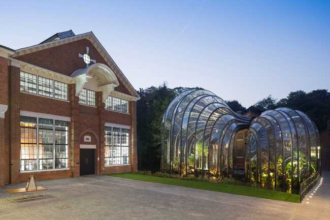 Glass greenhouse next to historic buildings