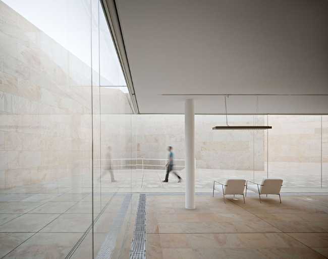 office building glass facade continuous stone flooring