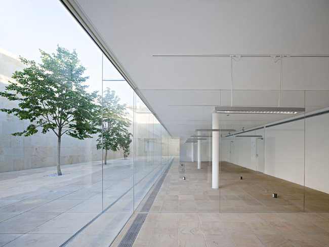 office building glass facade continuous stone flooring