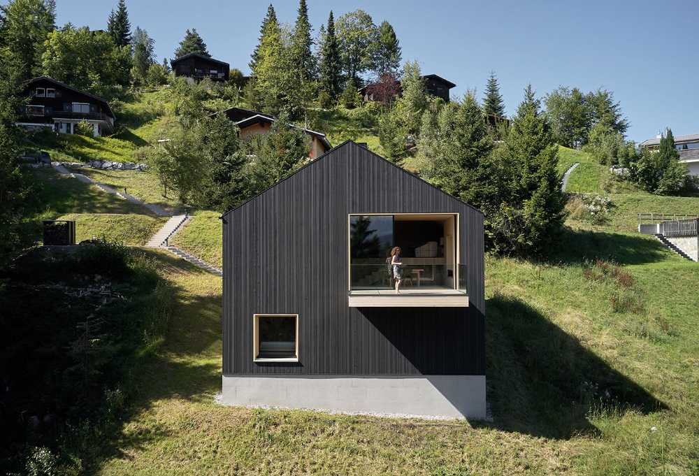 Maison de vacances en bois massif. La forme et la couleur interagissent avec les bâtiments environnants