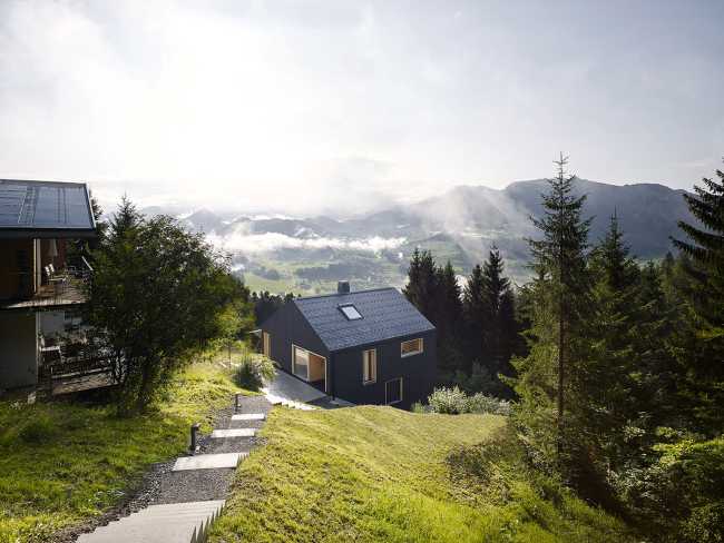Maison de vacances en bois massif. La forme et la couleur interagissent avec les bâtiments environnants