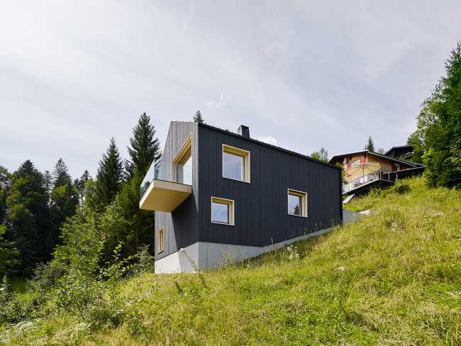 Maison de vacances en bois massif. La forme et la couleur interagissent avec les bâtiments environnants