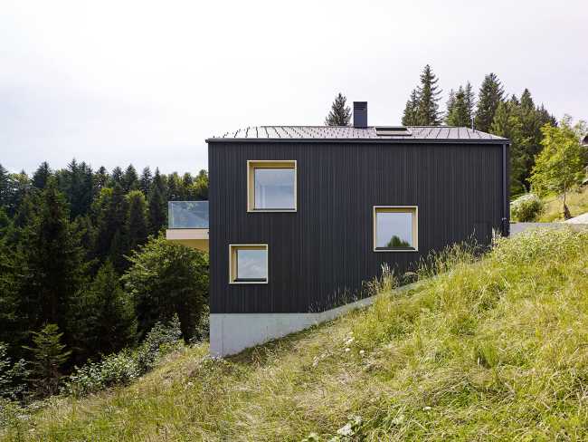 Maison de vacances en bois massif. La forme et la couleur interagissent avec les bâtiments environnants