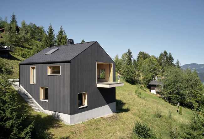 Maison de vacances en bois massif. La forme et la couleur interagissent avec les bâtiments environnants