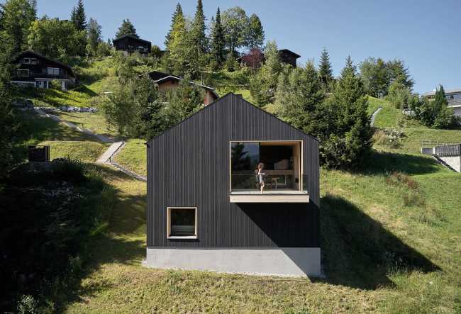 Maison de vacances en bois massif. La forme et la couleur interagissent avec les bâtiments environnants