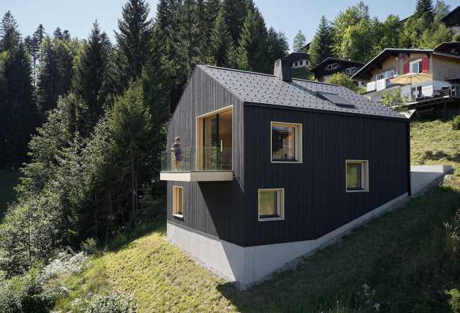 Maison de vacances en bois massif. La forme et la couleur interagissent avec les bâtiments environnants