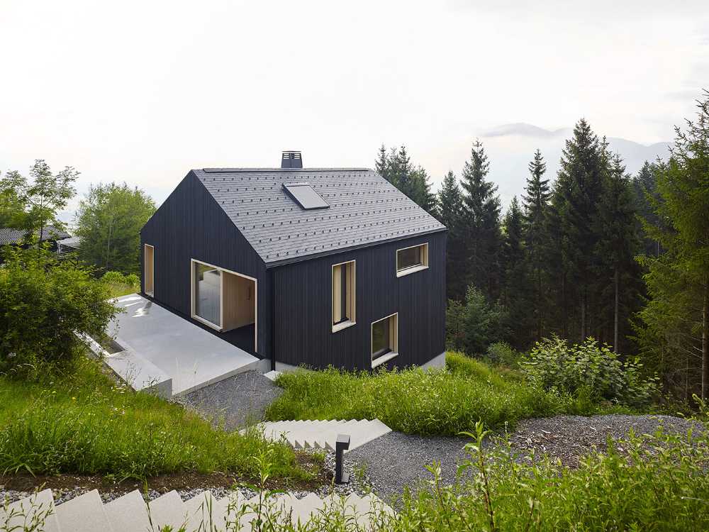 Maison de vacances en bois massif. La forme et la couleur interagissent avec les bâtiments environnants