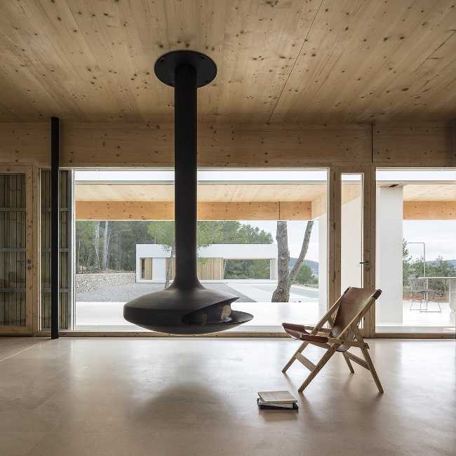 villa Ibiza intérieur cheminée suspendue, plafond avec revêtement en bois, sol en pierre