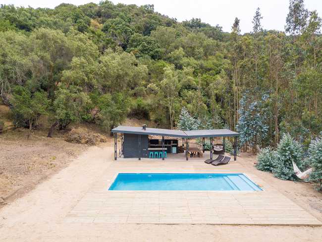 Wooden house among the trees with swimming pool