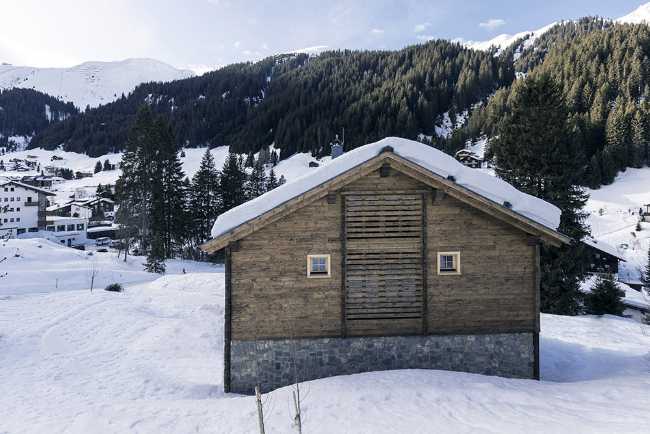 Wooden house in the snow-capped mountains