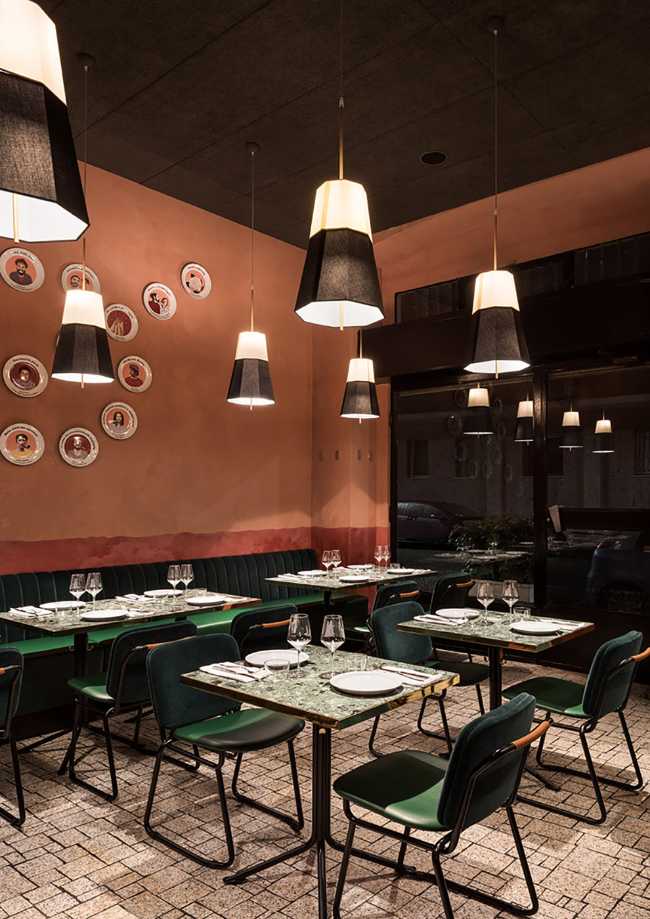 Sala RŎST in Milan, plates on the wall color marsala and tables