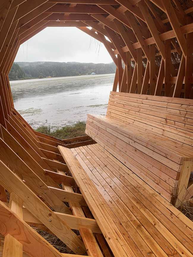 Circular interior wooden pavilion with internal seat