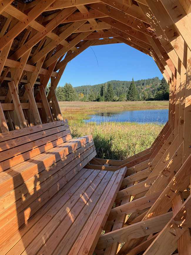 Circular interior wooden pavilion with internal seat