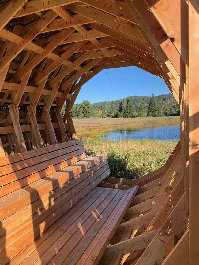 Circular interior wooden pavilion with internal seat
