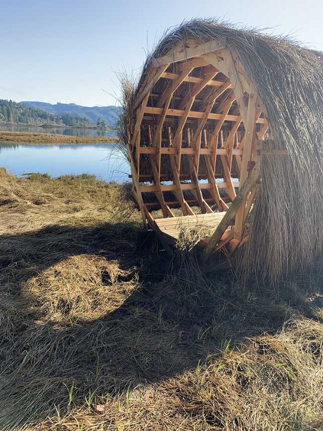 Circular wooden pavilion covered with straw