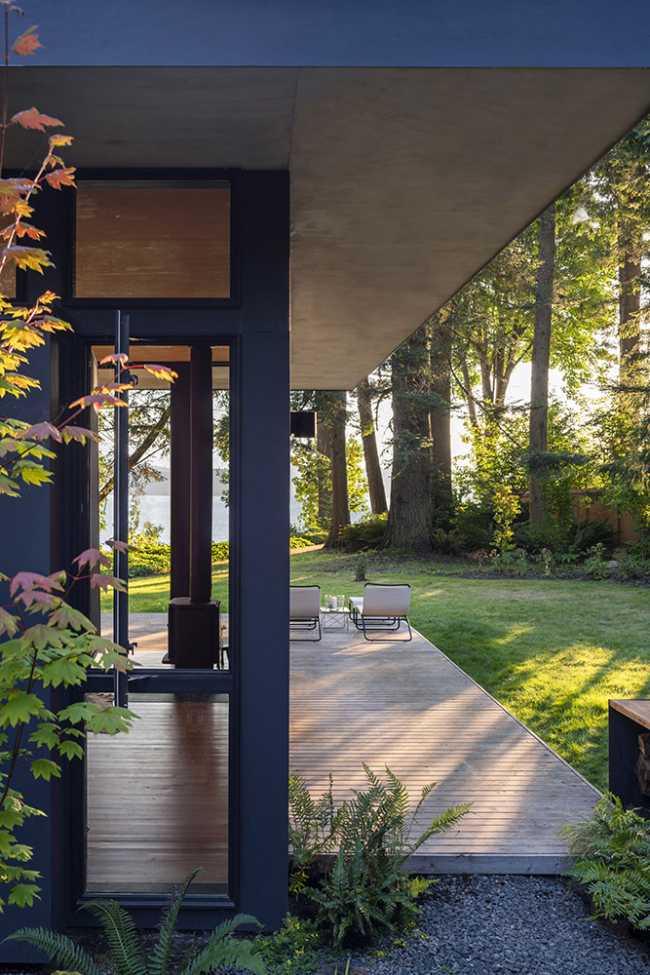 Cabane en bois avec des lumières de coucher de soleil entre les arbres.