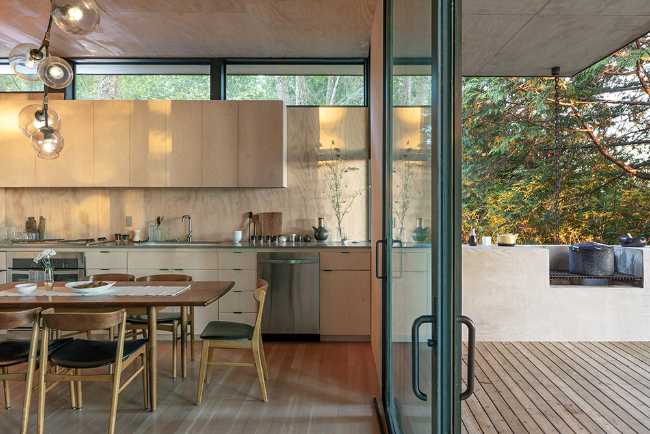 Intérieur de la cuisine avec une baie vitrée donnant sur le balcon.