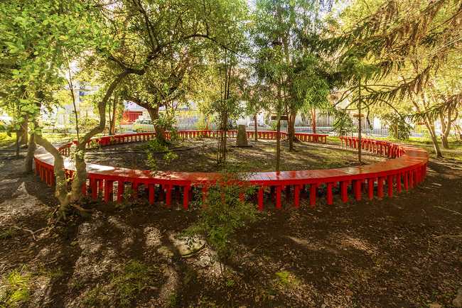 Red continuous circular wooden bench