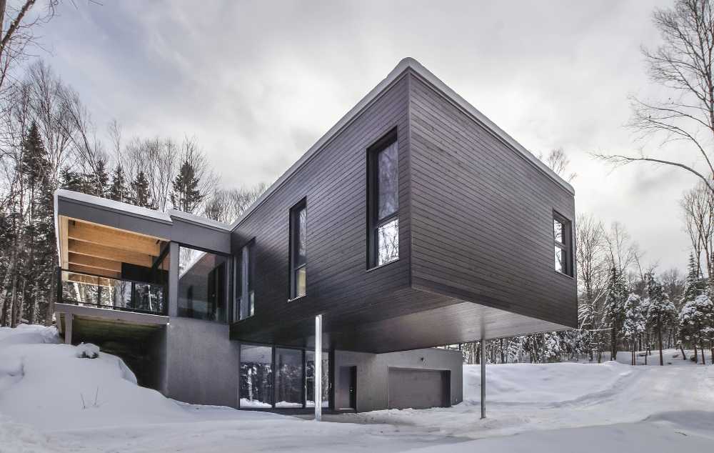 Lodge intégré à la roche. Un volume en porte-à-faux flotte au cœur de la forêt