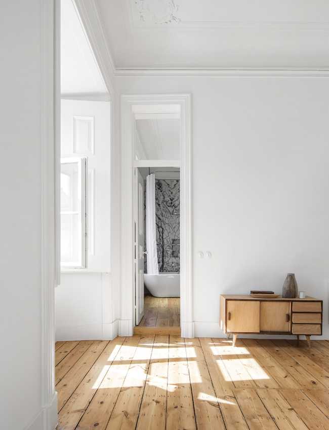 Stanza con pareti bianche e parquet