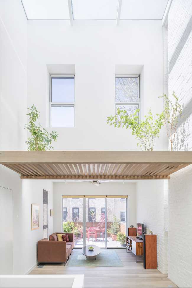 Interior renovation in Brooklyn. Triple-height space at the center of living spaces