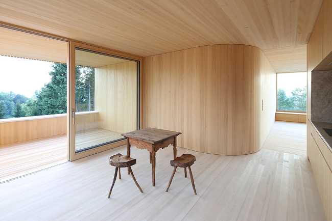 Interno abitazione in legno minimal con parete curva