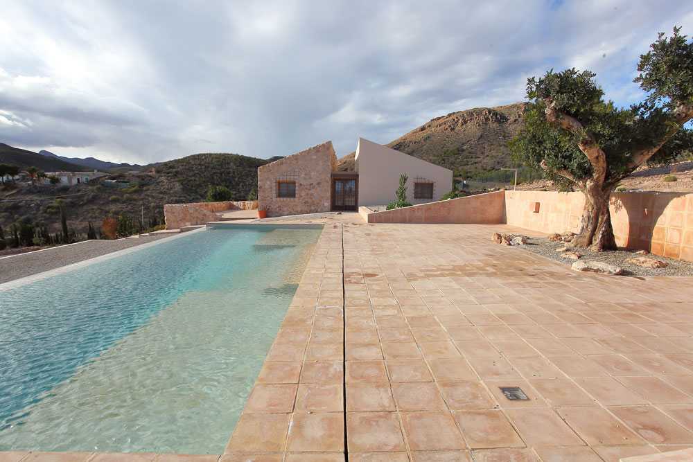 Mediterranean house situated between ploughed fields and stones. Ecological habitat in Spain