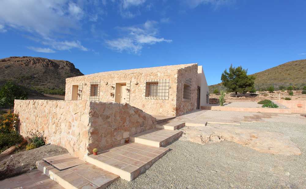 Casa mediterránea ubicada entre campos arados y piedras. Hábitat ecológico en España